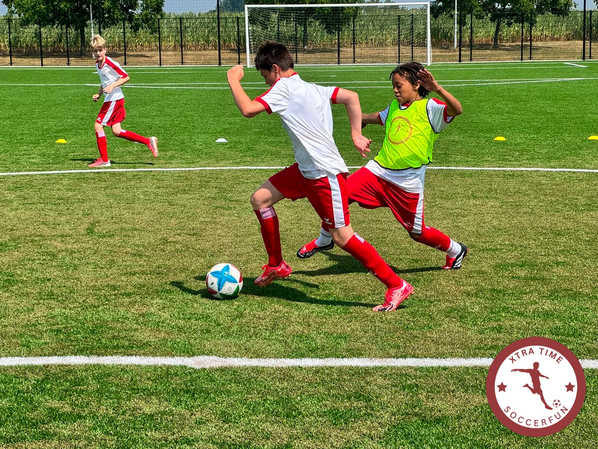 Een trainer begeleidt een speler van Xtra Time Soccerfun